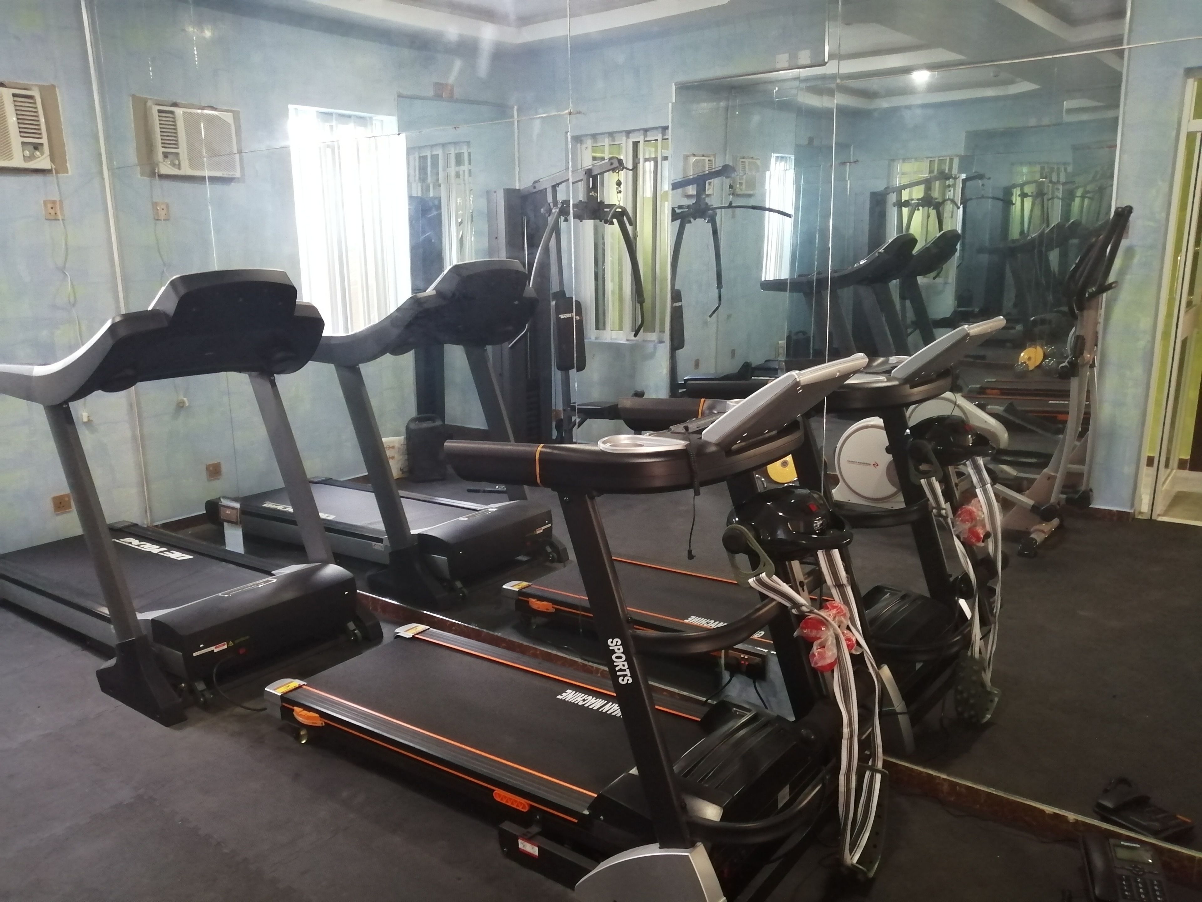 A gym with treadmills, elliptical machines, and exercise bikes.