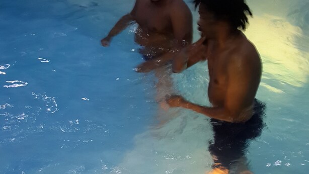 A swimming pool with two people in the water. - GrandVenice Transit Apartments (Lagos)