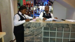 A bar area with a marble counter and shelves of various bottles in the background. - GrandVenice Transit Apartments (Lagos)