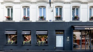 Un edificio con fachada negra, múltiples ventanas con jardineras y un letrero que indica Hotel Prince Albert.