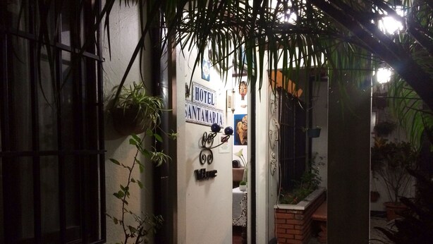A narrow hallway with a sign reading "HOTEL SANTAMARIA," a potted plant, and a tiled floor. - Hotel Santamaria (Alajuela)