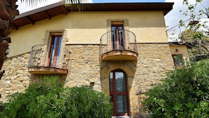 Un bâtiment en pierre doté de deux balcons et d’une entrée centrale.