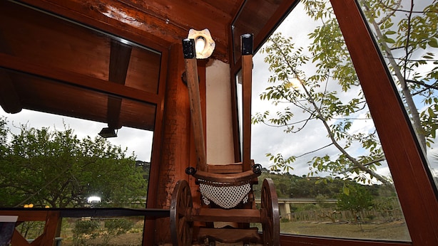 Un intérieur rustique en bois, agrémenté d’une grande fenêtre donnant sur un jardin.
