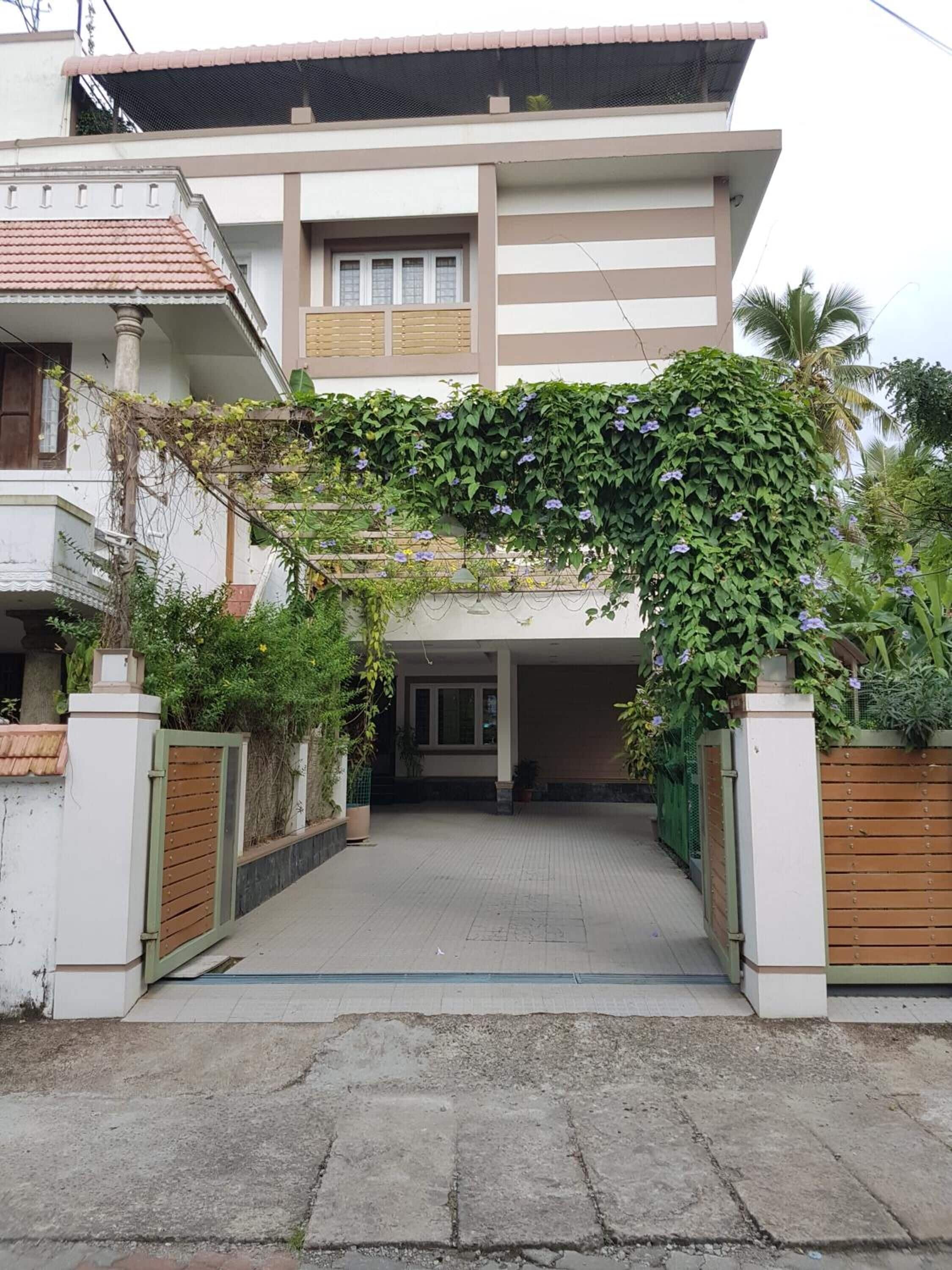 A two-story house with a covered entrance and a gated driveway.