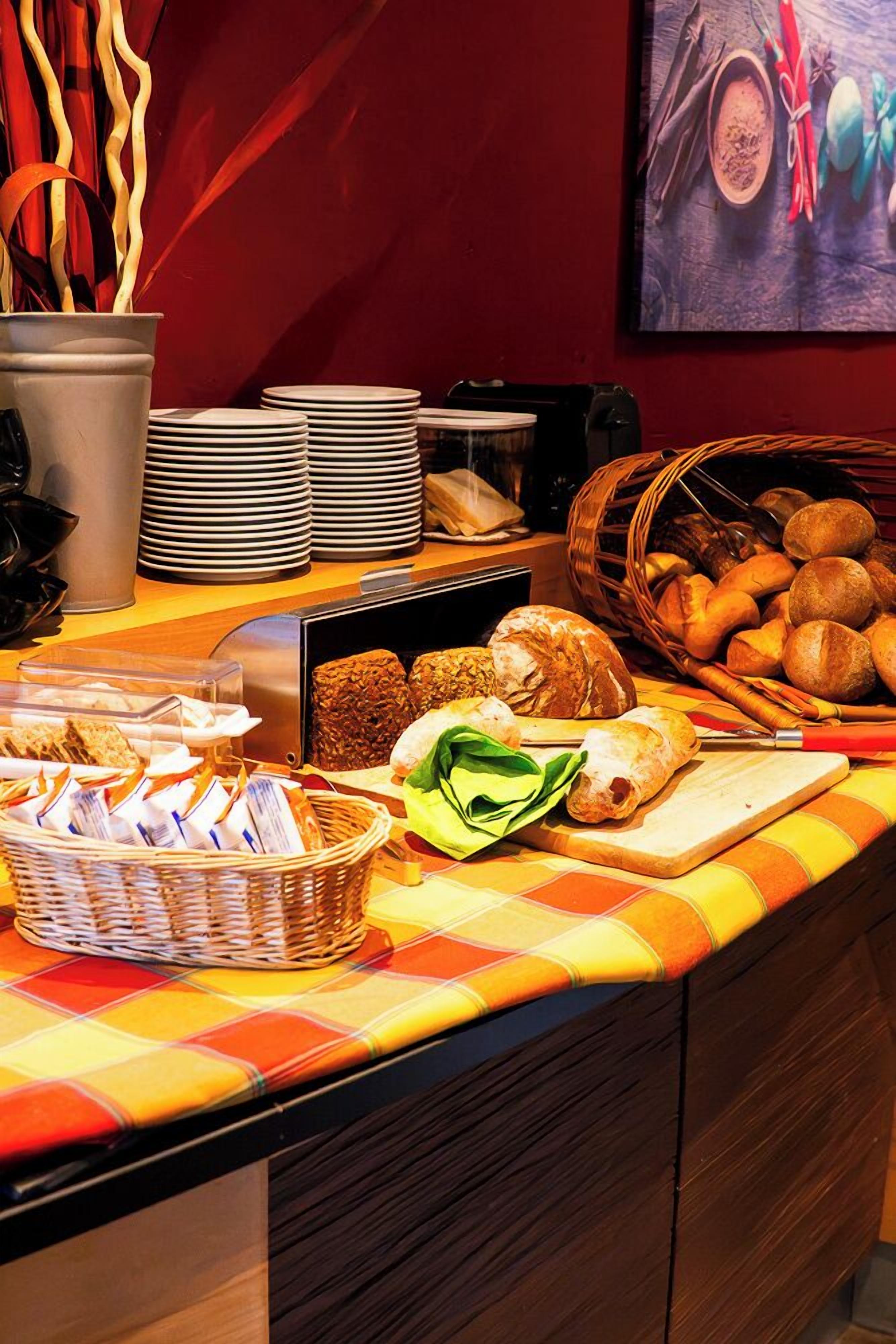 Buffet com diversos alimentos, incluindo pão, doces e salada.