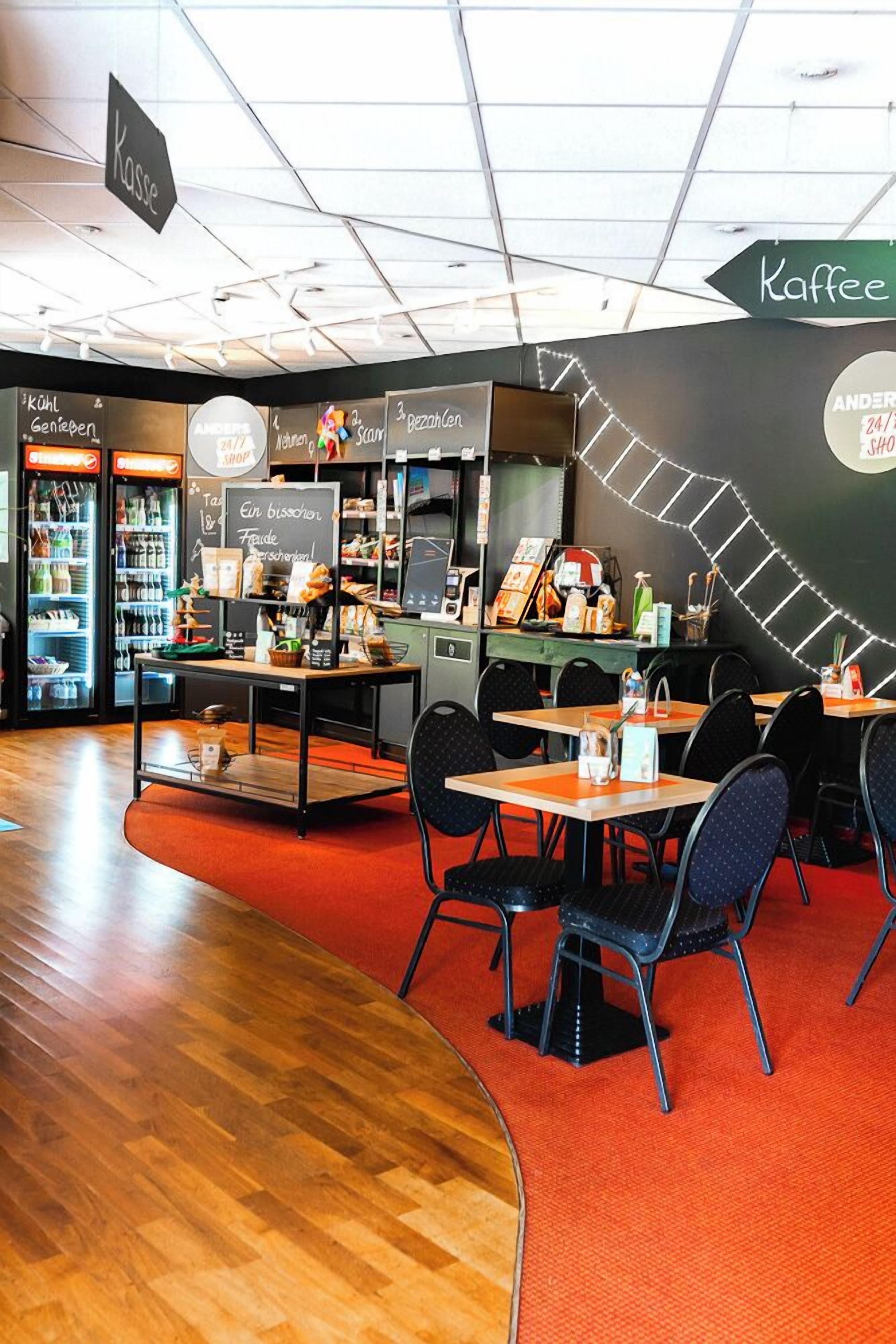 A cafe with tables and chairs, a coffee machine, and shelves with products.