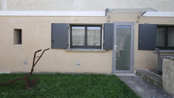 A building with a beige exterior, numbered doors 20 and 21, and a small window with shutters.