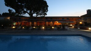 A hotel with a swimming pool, outdoor seating, and a large tree. - Hotel Van Gogh (St.-Rémy-de-Provence)