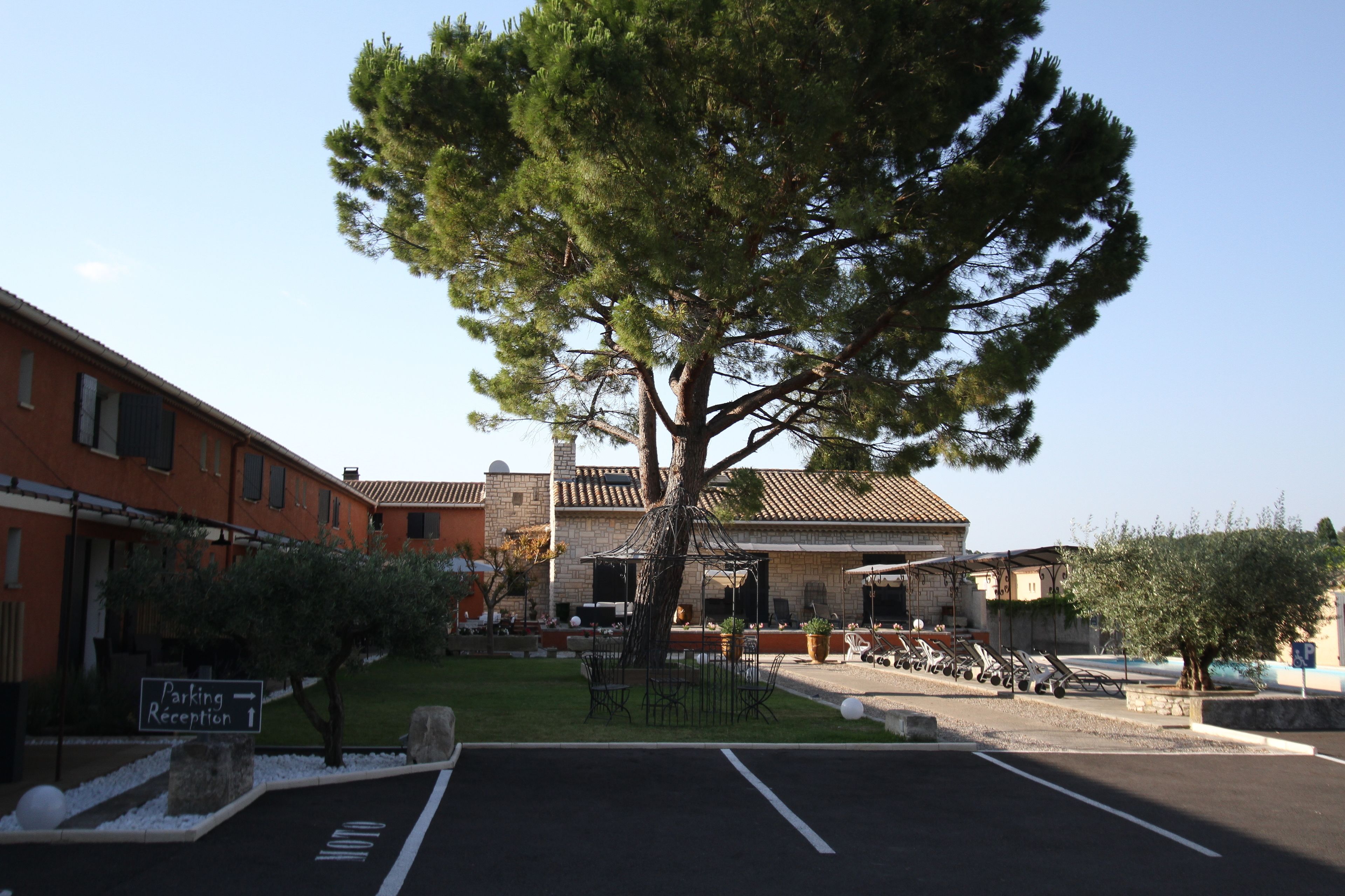 A building with outdoor seating and a parking area.