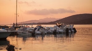 A marina with several boats docked at sunset. - Camping Village Capo D'Orso (Palau)
