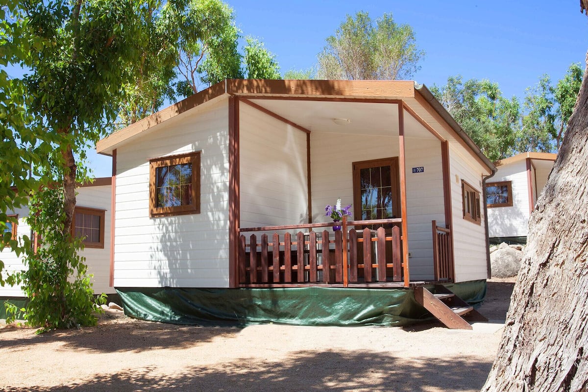 Une maison mobile de plain-pied, dotée d’un porche, d’une petite fenêtre et d’une plaque portant le numéro « 707 ».
