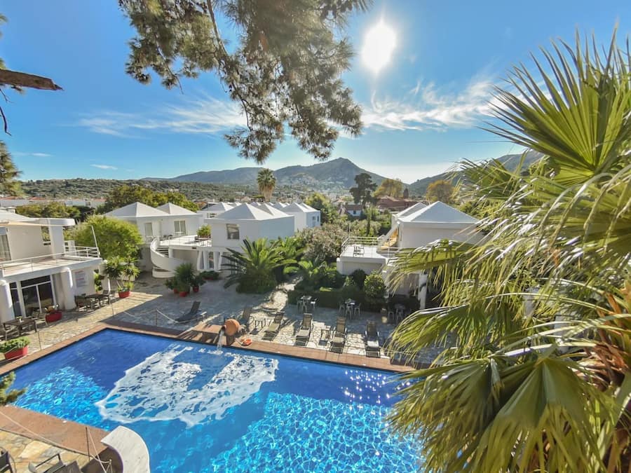 Una piscina al aire libre, sombrillas, sillones reclinables de piscina