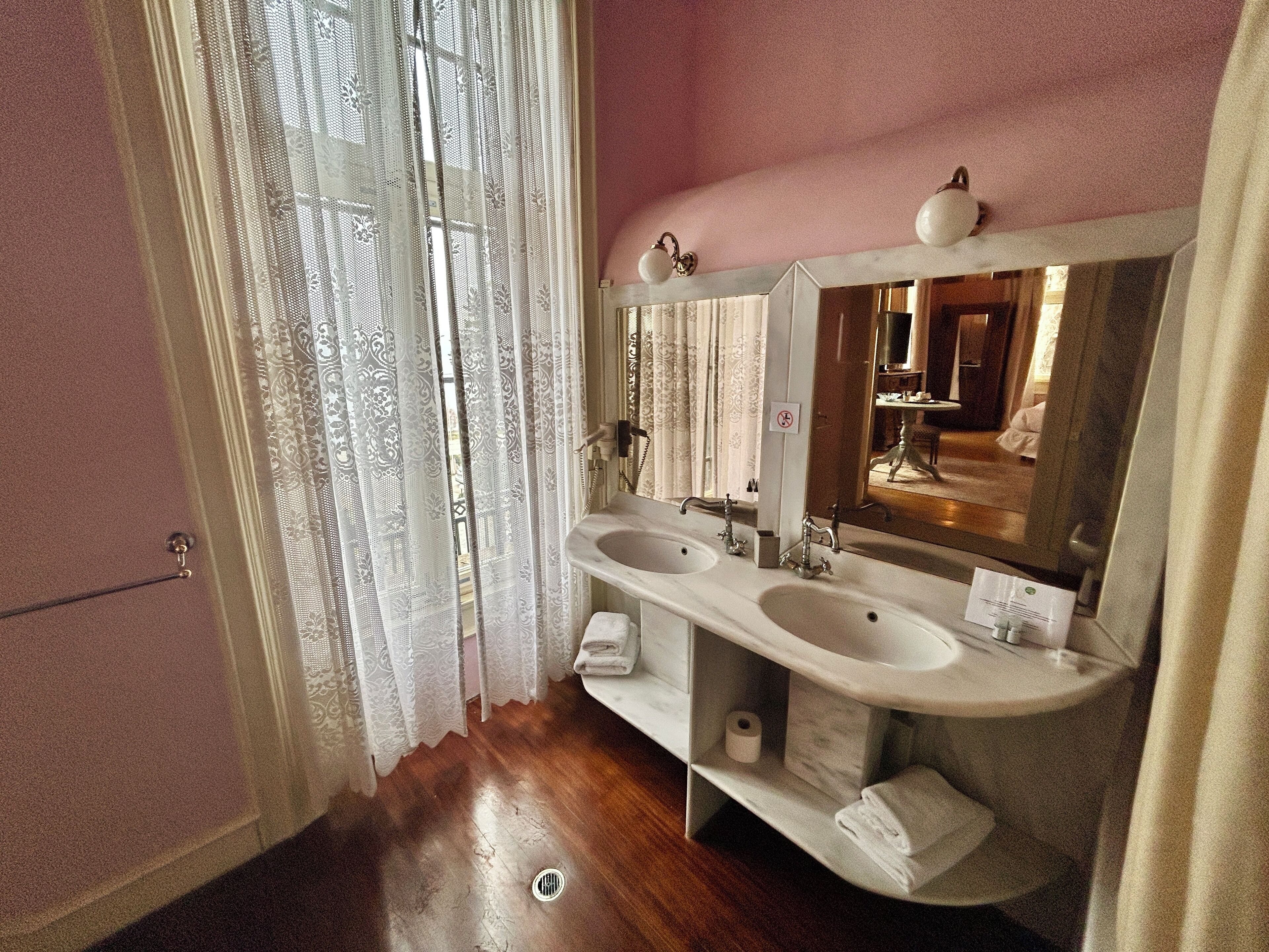 Une salle de bain avec deux lavabos, un miroir et des toilettes.