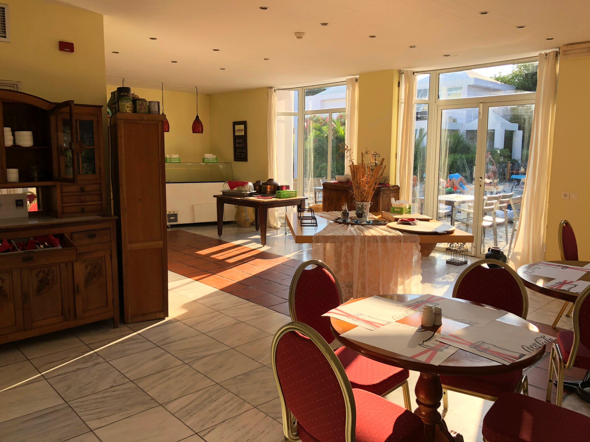 A spacious dining area with large windows, a kitchen with wooden cabinets, and a cozy seating arrangement.