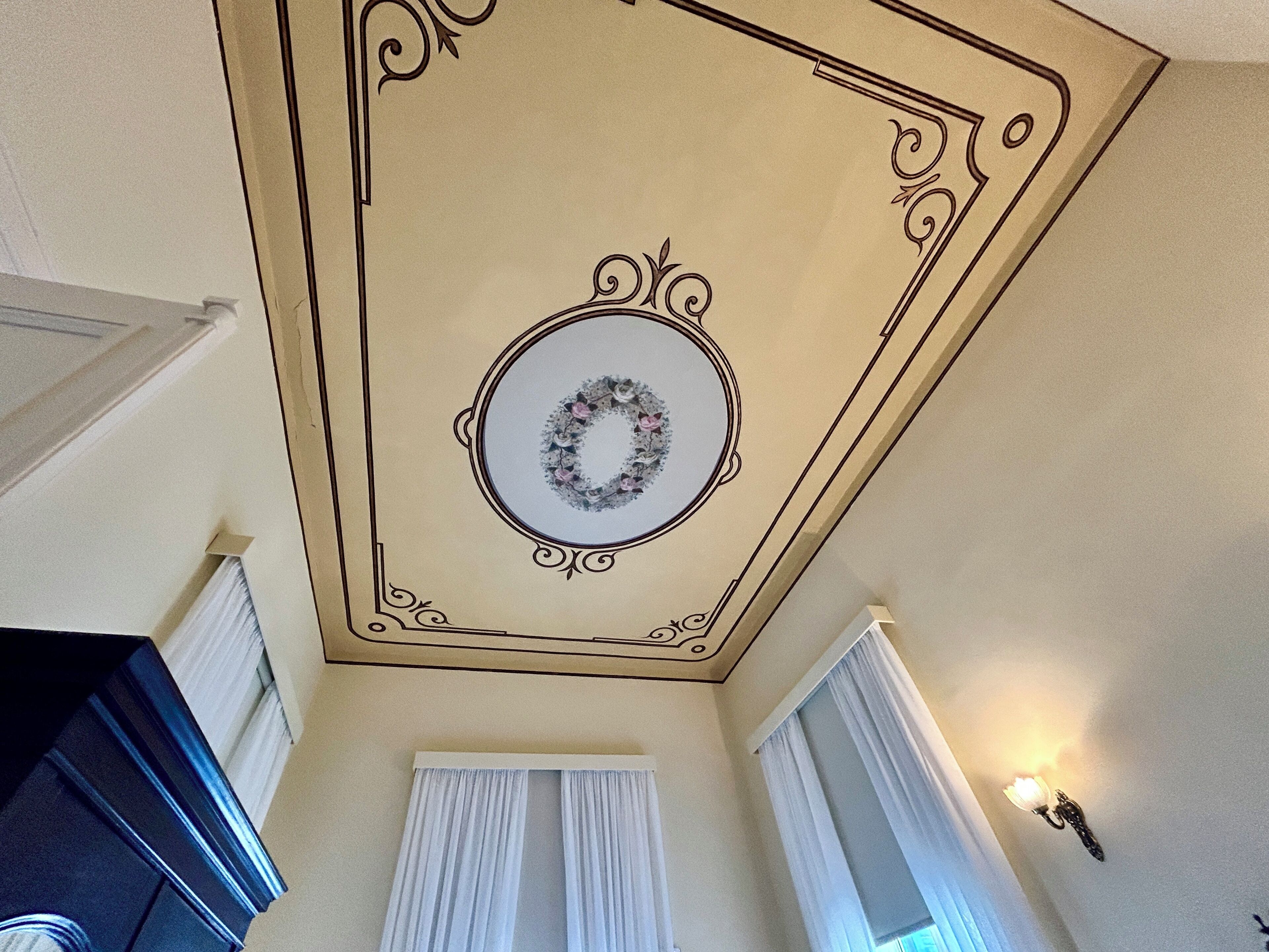 Techo con un diseño decorativo, un adorno circular y una lámpara.
