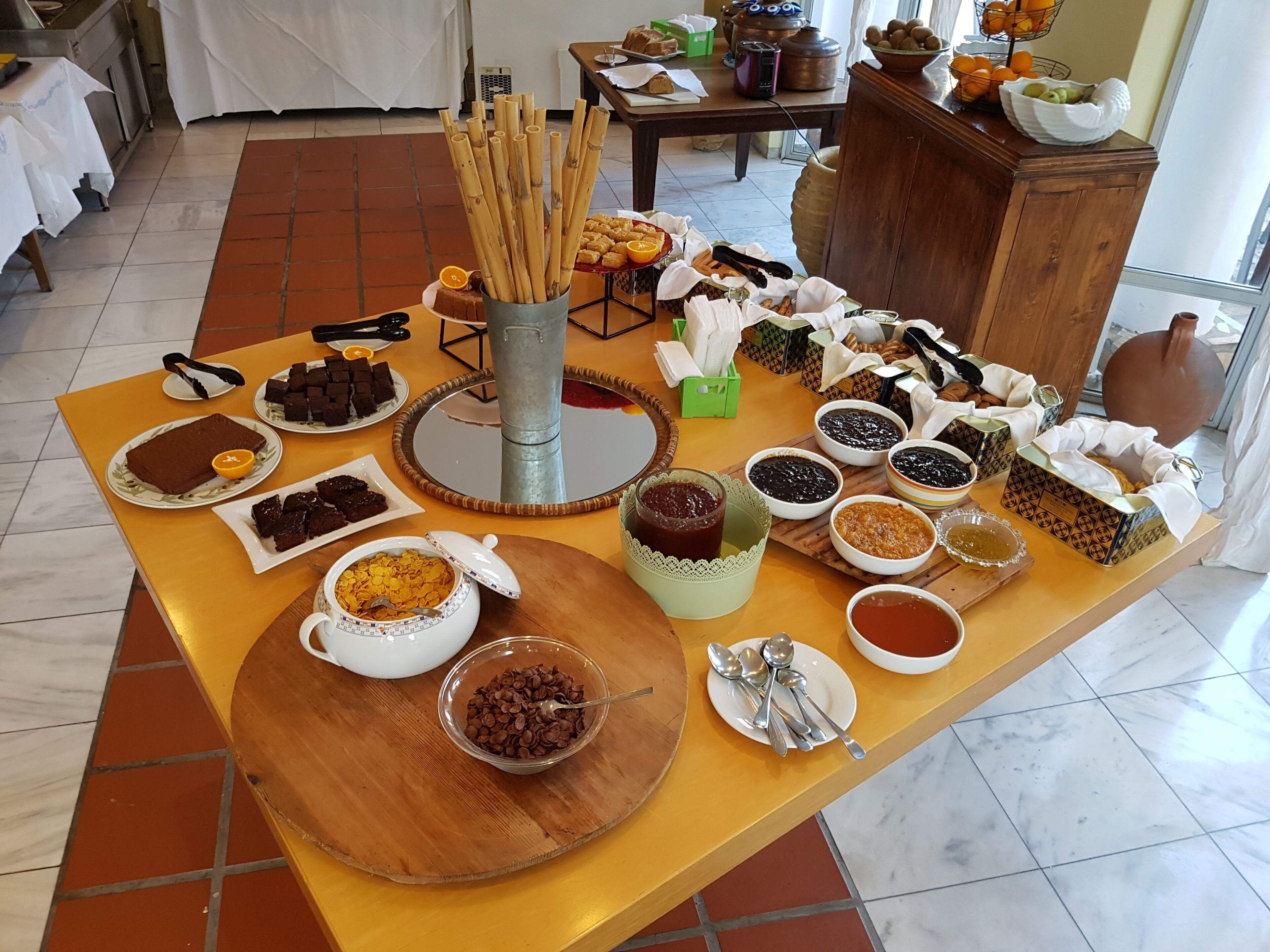 Una mesa de bufé con diversos alimentos y utensilios.