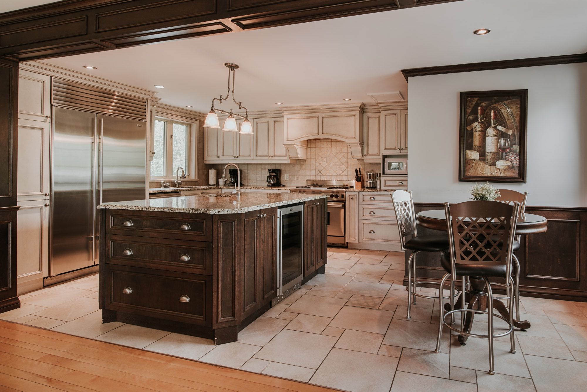 A modern kitchen with a large island, stainless steel appliances, and a dining area with a table and chairs.