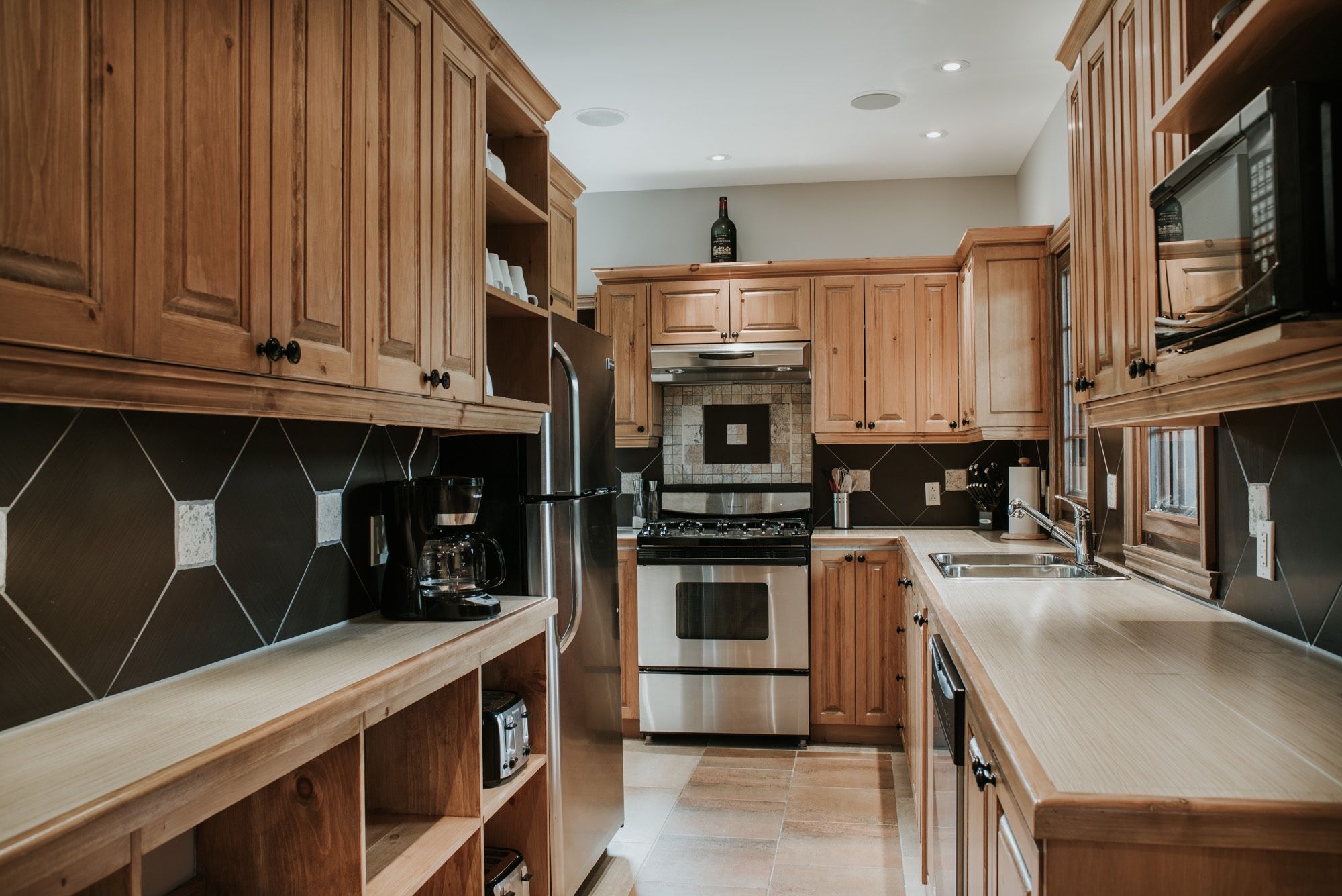 A kitchen with wooden cabinets, a stainless steel stove, and a microwave.