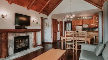Amplia sala de estar con chimenea, una mesa de comedor de madera y un sofá.