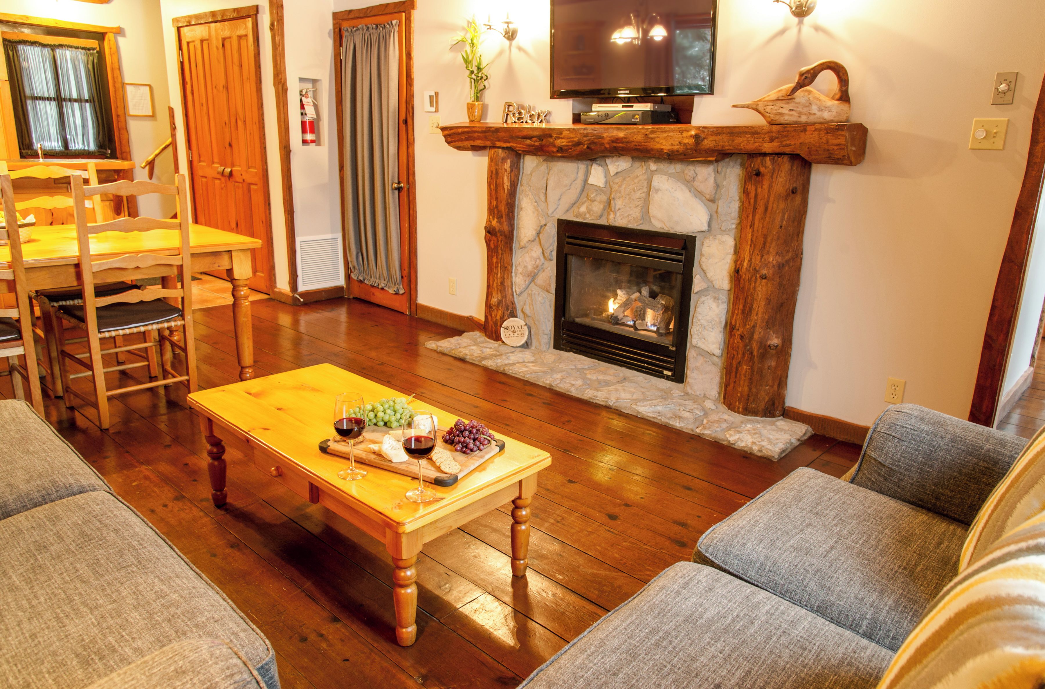 Sala de estar com lareira, móveis de madeira e televisão.