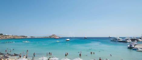 On the beach, white sand, sun loungers, beach umbrellas