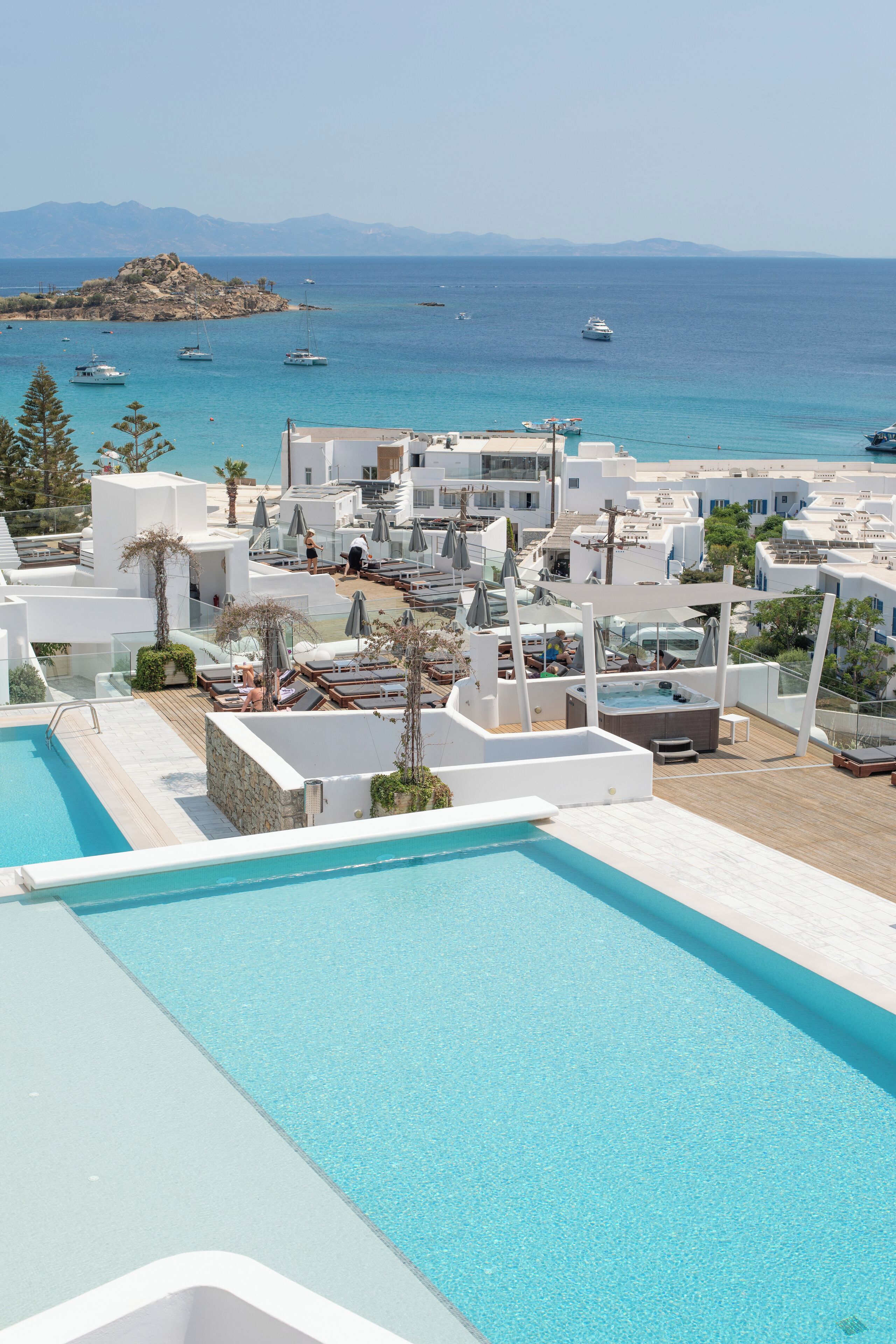 Un complex turístic amb piscina, zones d'esbarjo i vistes al mar i a les muntanyes.