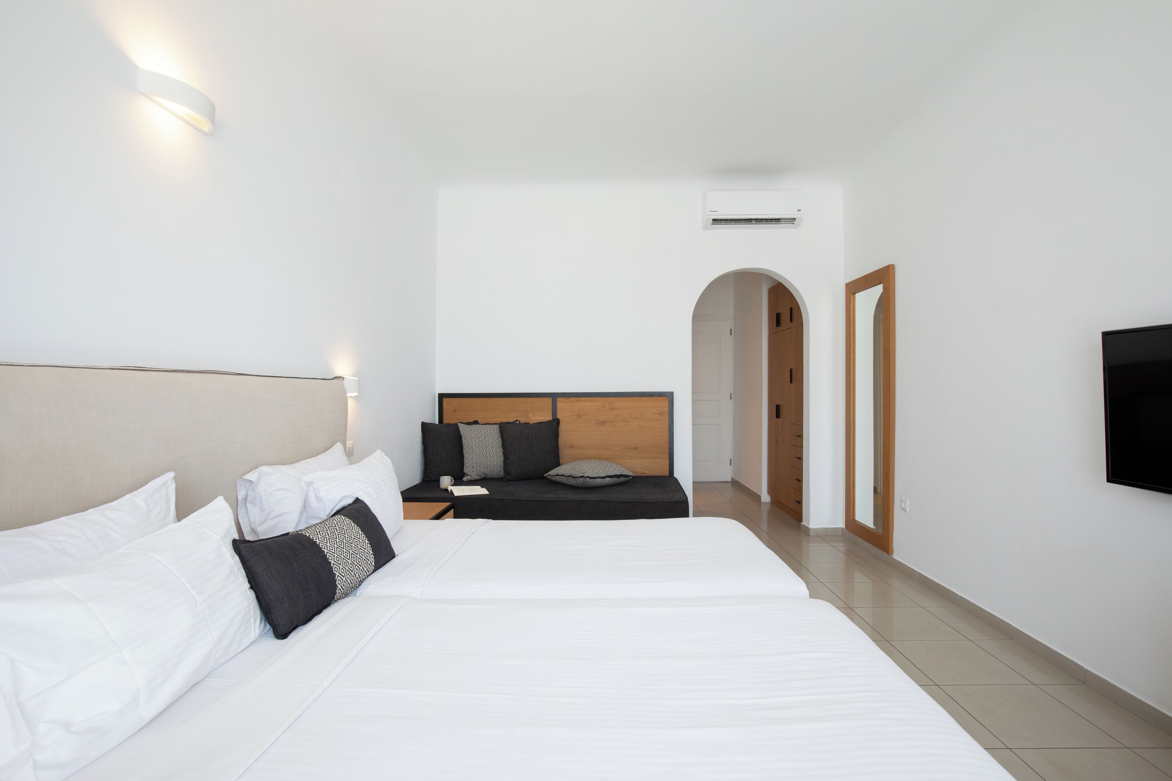 Une chambre d’hôtel avec deux lits, une télévision et une porte en bois.