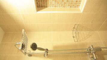 A shower with a handheld showerhead and a handheld shower head with a rain shower attachment.