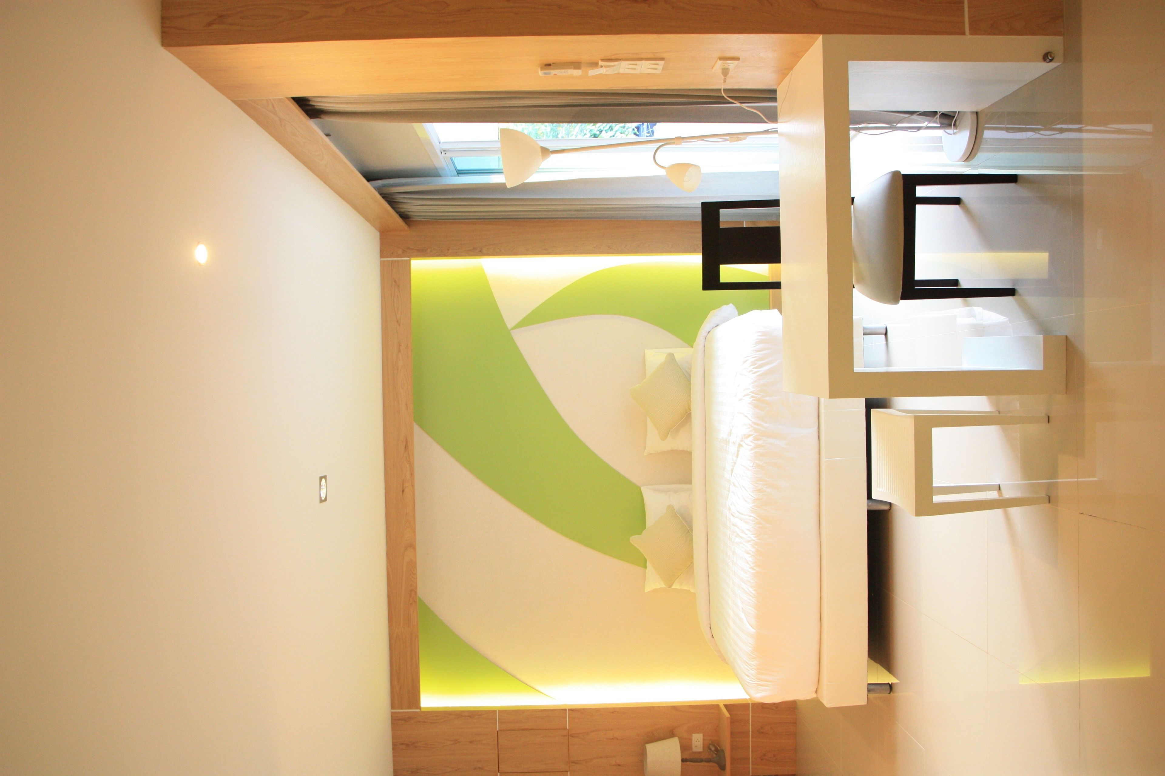 A modern bedroom with a bed, a bedside table, and a built-in TV.