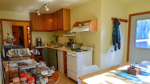 Una cocina compacta con armarios de madera, estufa y comedor con mesa y sillas.
