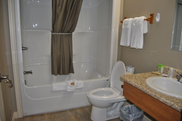 A bathroom with a bathtub, toilet, and sink.