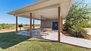 A covered outdoor area with picnic tables and a barbecue grill. - Risewell Kitchen Suites Pleasanton (Pleasanton)