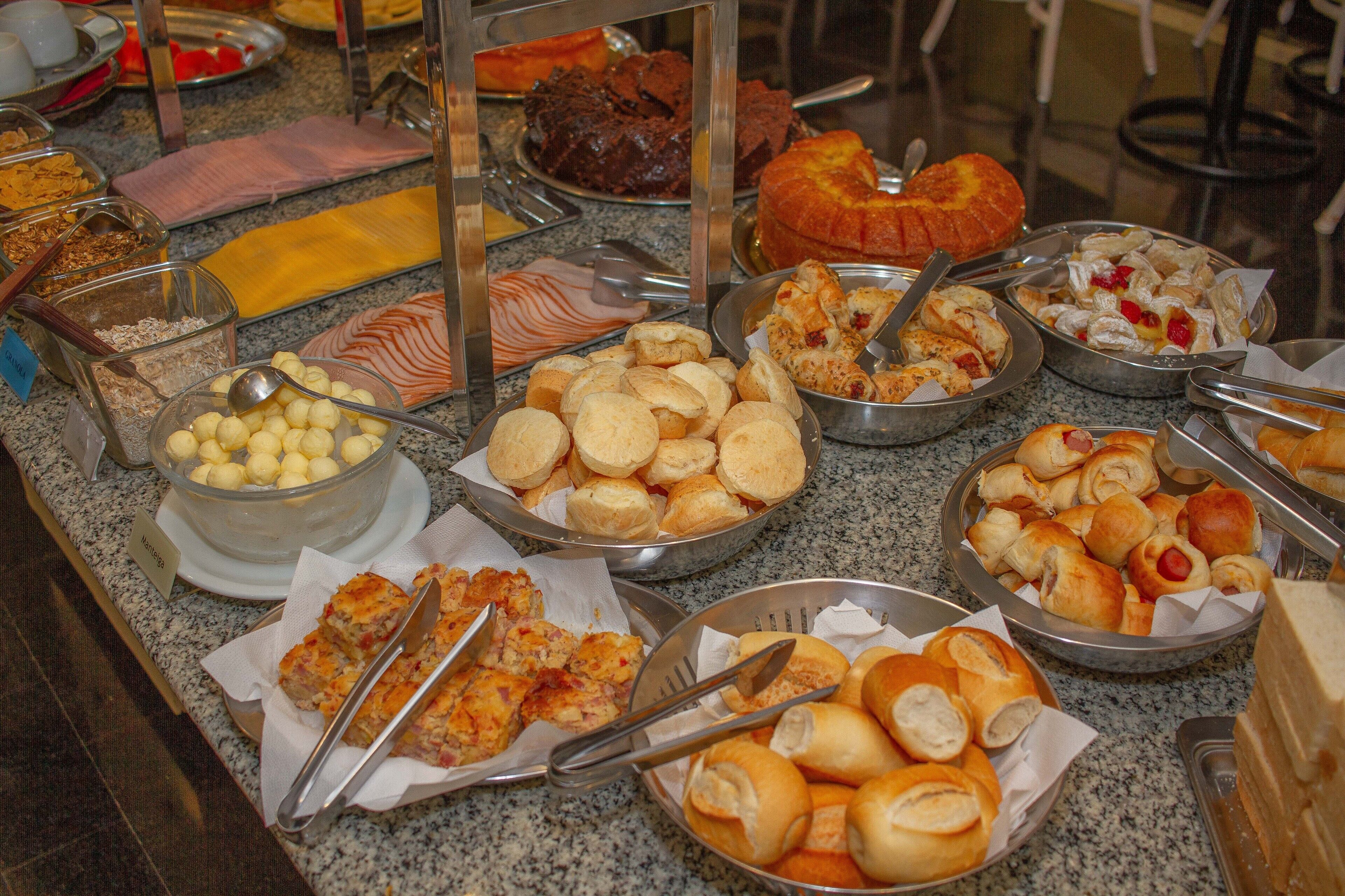 A buffet with various food items including bread, pastries, and desserts.