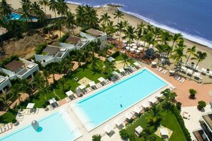 Outdoor pool, pool umbrellas - Unlimited Luxury Villas - Icon Vallarta Condo (Puerto Vallarta)