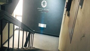A staircase leading to a room with a sign reading "PHILSTAY EHWA BOUTIQUE Hostel B&B". - Philstay Ehwa Boutique (Seoul)