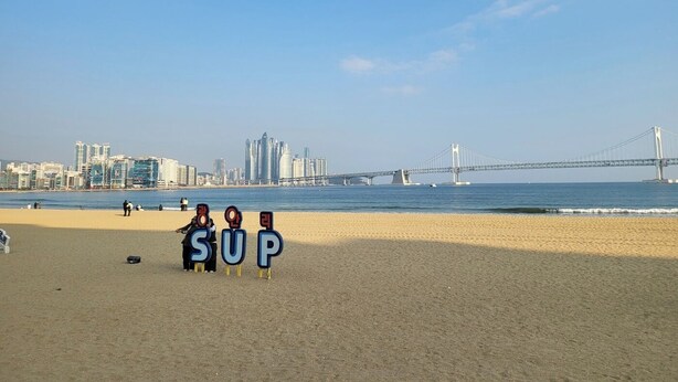 A beach with a large bridge in the background and a city skyline. - Philstay Ehwa Boutique (Seoul)