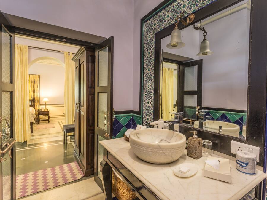 A bathroom with a large mirror, a sink, and a towel rack.