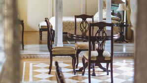 Une pièce richement décorée, avec un sol à carreaux, un lit recouvert d’une couvre-lit à motifs et un lustre.