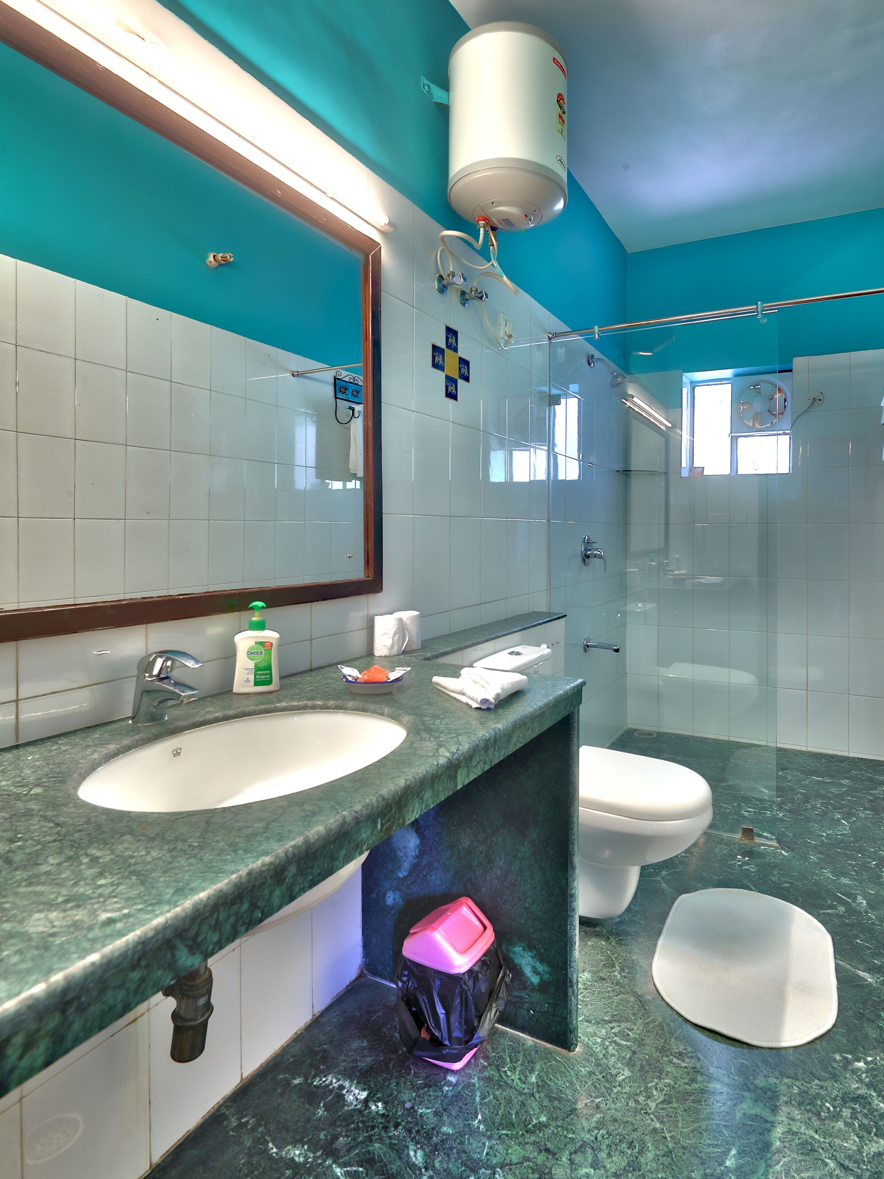 A modern bathroom with a large mirror, a sink, a toilet, and a shower area.