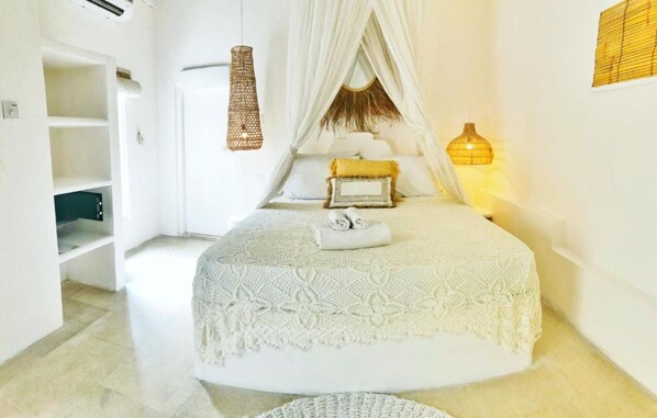 Une chambre à coucher avec un lit à baldaquin, une lampe de chevet et une petite table de chevet.