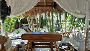 A covered outdoor seating area with a table, chairs, and a lantern. - Sal Secret Spot (Pecatu)