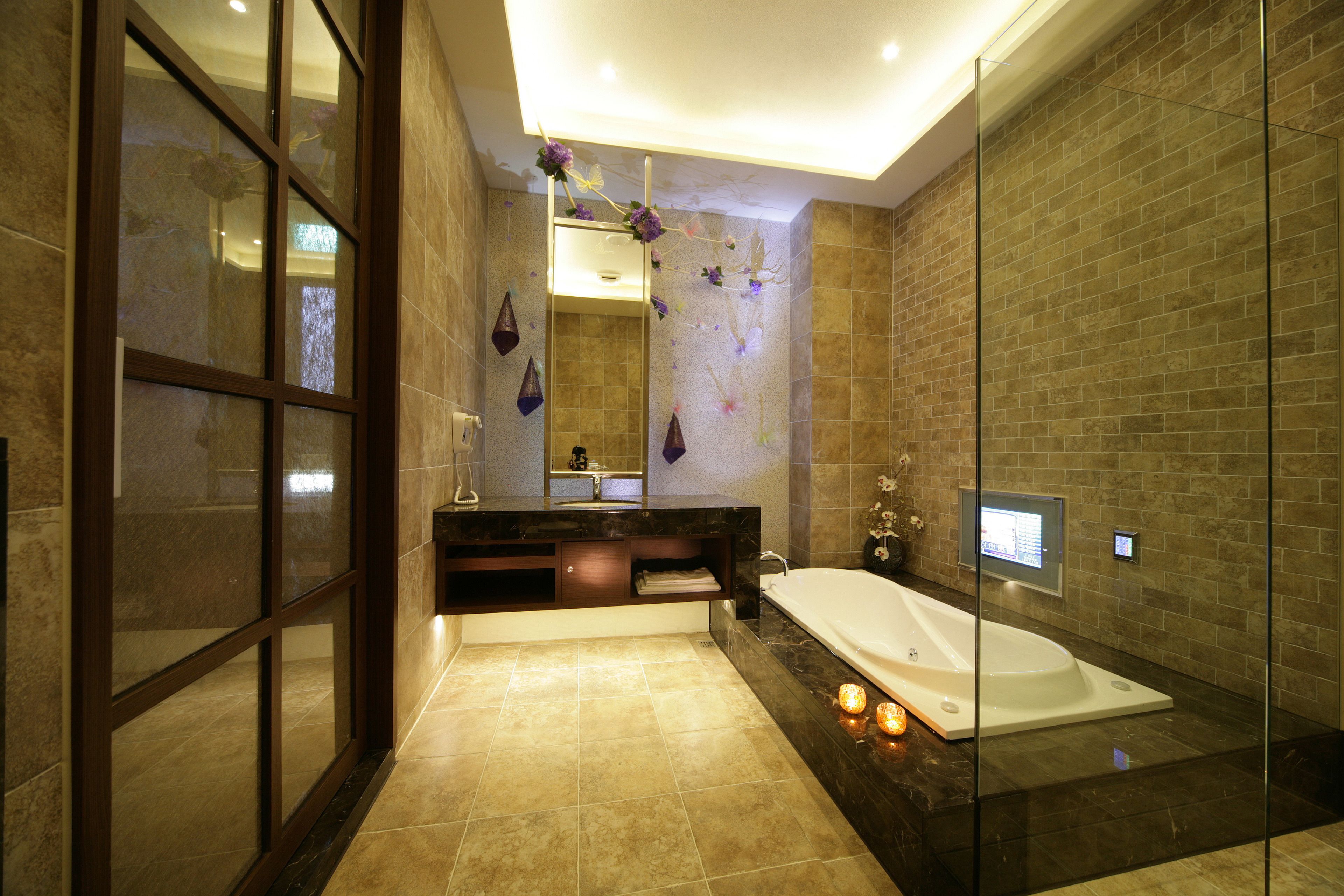A modern bathroom with a glass shower enclosure, a large bathtub, and a vanity with a mirror.