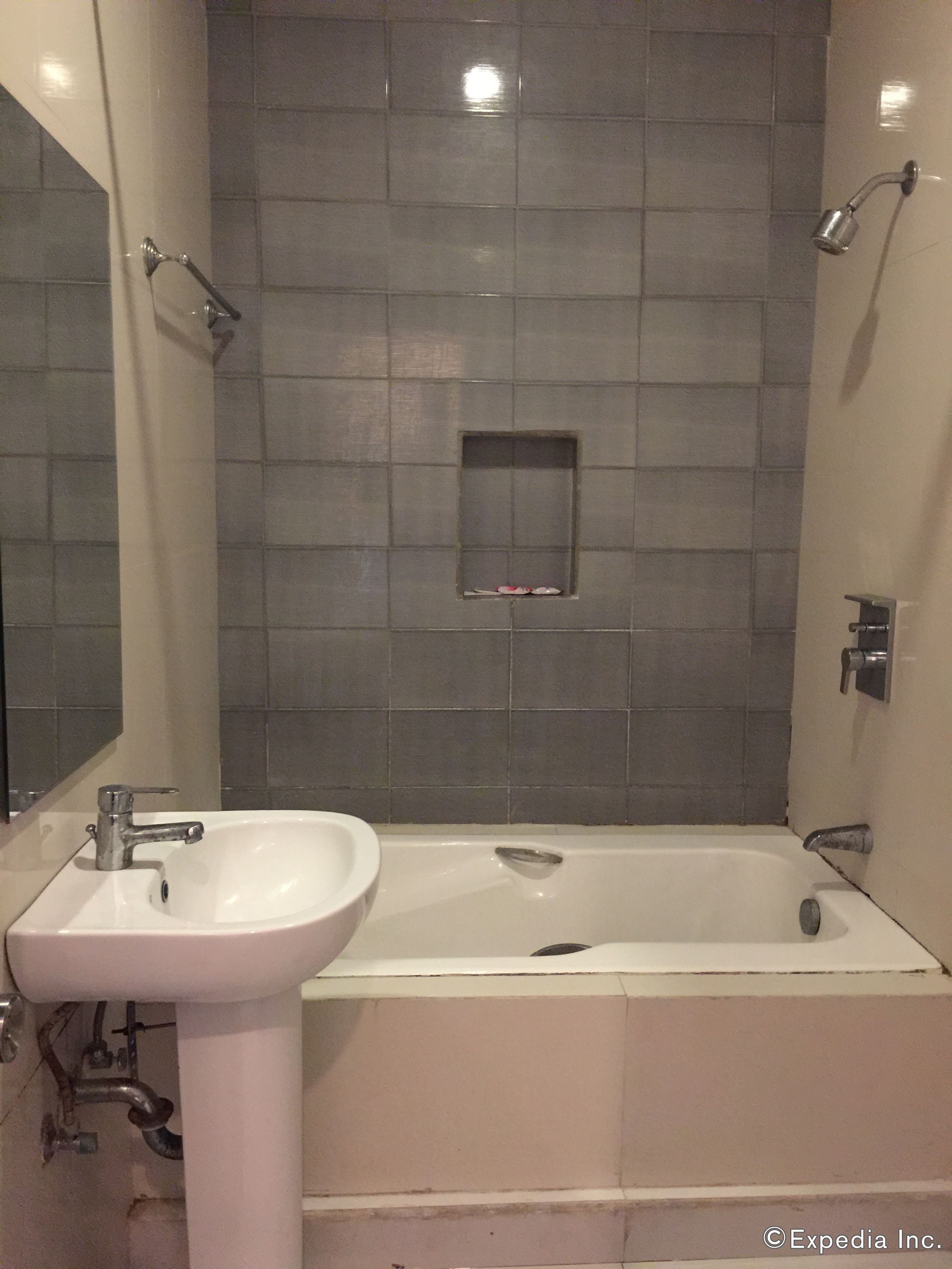 A bathroom with a white sink, a bathtub, and a shower.