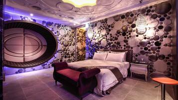 Un dormitorio moderno con un diseño de pared circular, una cama, una silla roja y una mesita.