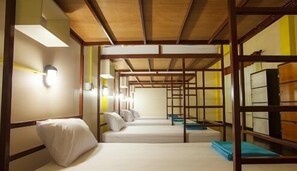 A room with bunk beds, wooden beams, and a simple, functional design. - FUN-D Hostel Chiang rai (Chiang Rai)