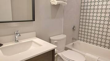 Un baño moderno con lavamanos, inodoro y bañera.