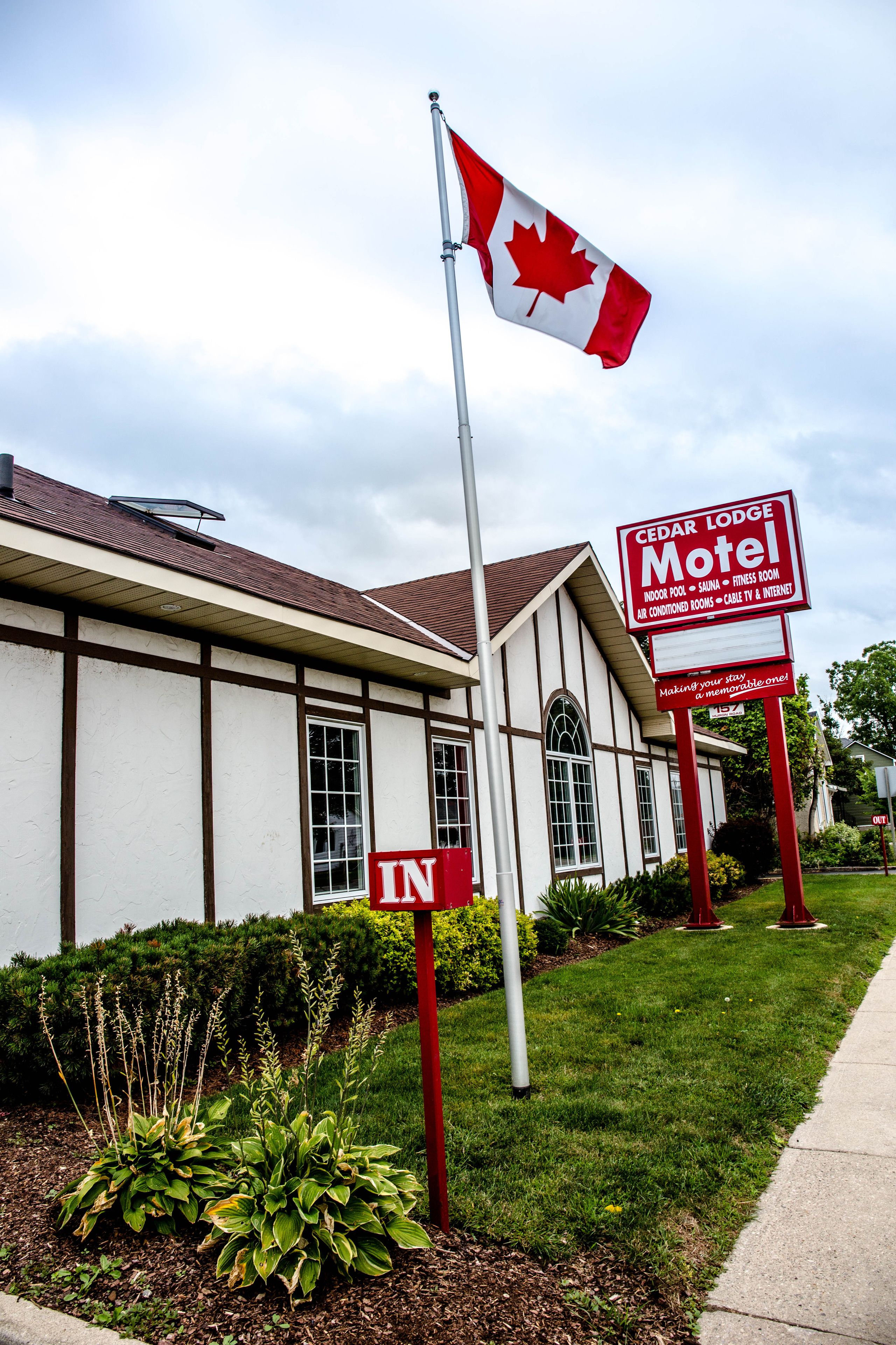 A motel with a flag, a sign, and a 'No Parking' sign.