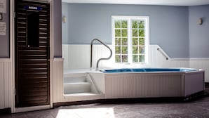 A spa room with a sauna, a window with a view of greenery, and a hot tub. - Cedar Lodge Motel (Goderich)