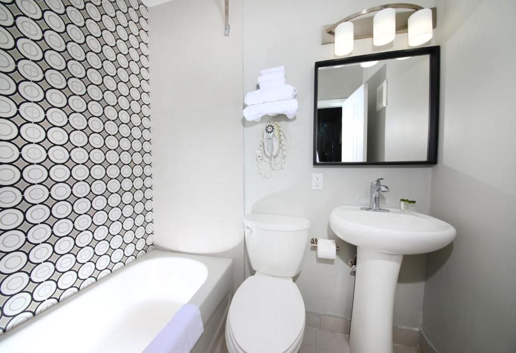 A bathroom with a toilet, sink, and bathtub.