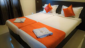 Une chambre d’hôtel avec un lit double, deux oreillers et deux serviettes pliées posées sur le lit.